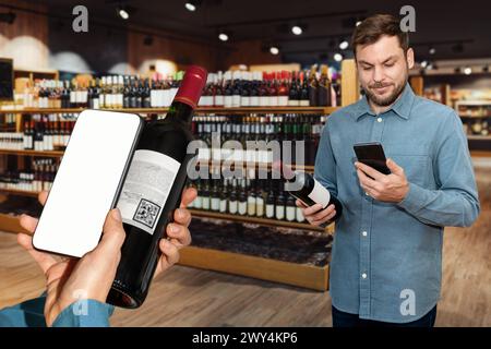 I clienti di un'enoteca scansionano le etichette elettroniche delle bottiglie di vino e leggono informazioni sul vino utilizzando il telefono cellulare. Foto Stock