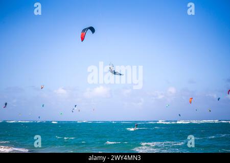 Kiteboarding. Divertimento nell'oceano. Sport estremo Kitesurf. Kitesurfer che salta in alto nell'aria che esegue le trick durante la sessione di kitesurf Foto Stock