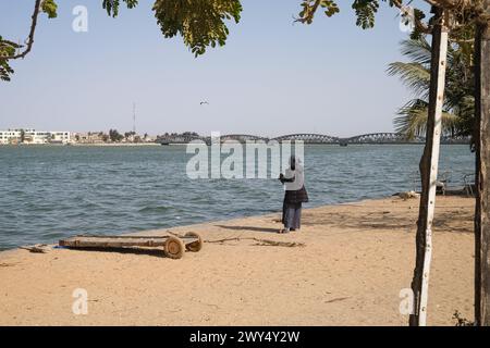 Saint Louis, Senegal. 31 marzo 2024. © Nicolas Remene/le Pictorium/MAXPPP - Saint-Louis 31/03/2024 Nicolas Remene/le Pictorium - 31/03/2024 - Senegal/Saint-Louis/Saint-Louis - un homme prie au bord du Fleuve Senegal et devant le Pont Faidherbe a Saint-Louis, le 31 mars 2024. - Valeurs ACtuelles out, no jdd, jdd out, RUSSIA OUT, NO RUSSIA #norussia/31/03/2024 - Senegal/Saint-Louis/Saint-Louis - Un uomo prega sulle rive del fiume Senegal di fronte al ponte Faidherbe a Saint-Louis, 31 marzo 2024. Crediti: MAXPPP/Alamy Live News Foto Stock