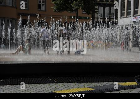 I bambini giocano in una fontana dinamica ad Hameln, in Germania Foto Stock