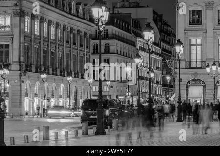 Parigi, Francia - 17 febbraio 2024: Vista dei lampioni illuminati nella trafficata Place Vendôme con i suoi negozi e hotel di lusso a Parigi in Francia Foto Stock