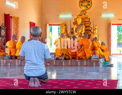 Wat Kaeng Khoi, Saraburi, Thailandia, 24 marzo 2024: All'interno della cappella, un vecchio si unisce a un gruppo di monaci per dire la preghiera. Foto Stock