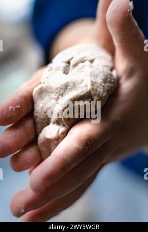 Il bambino si diverte a modellare l'impasto, attività autentica per lo sviluppo delle abilità motorie Foto Stock