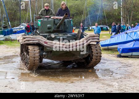 Studland, Dorset, Regno Unito. 4 aprile 2024. John Pearson, il restauratore e proprietario dell'unico carro armato completo e sopravvissuto Valentine Duplex Drive (anfibio), guida lungo le spiagge di Studland Bay, come parte dell'esercizio Smash 80th Anniversary per commemorare l'evento 80 anni fa, il 4 aprile 1944, dove circa 10.000 uomini furono coinvolti in un'esercitazione di fuoco vivo, tra cui il collaudo del carro anfibio Valentine Duplex Drive, dove sei uomini persero la vita e sette dei carri armati persero in mare. Crediti: Carolyn Jenkins/Alamy Live News Foto Stock