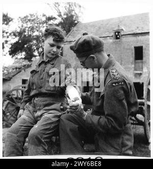 L'UFFICIALE MEDICO DELL'ESERCITO AGISCE COME MEDICO DEL VILLAGGIO QUANDO è fuori SERVIZIO - il MO visita un giovane ragazzo e gli esamina il braccio. Recentemente il MO ha ritenuto opportuno inserire il braccio in gesso. , British Army, 21st Army Group Foto Stock