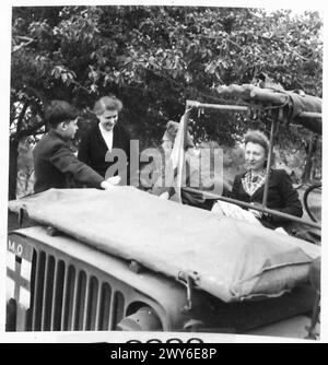 L'UFFICIALE MEDICO DELL'ESERCITO AGISCE COME MEDICO DEL VILLAGGIO QUANDO è fuori SERVIZIO - il MO parla con la madre del ragazzo e le assicura che tutto va bene. , British Army, 21st Army Group Foto Stock