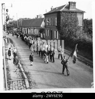 MOVIMENTO DI RESISTENZA FRANCESE NEL VILLAGGIO DI BEAUMESNIL EURE - membri della FFI che guidano la processione attraverso il villaggio sulla strada per il War Memorial. Sono stati raggiunti dagli abitanti del villaggio. , British Army, 21st Army Group Foto Stock