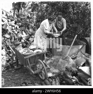 LA FAMIGLIA FRANCESE "TREASURE TROVE" HA SCAVATO I LORO OGGETTI DI VALORE DOPO ESSERE TORNATA A CASA LORO - M. E MME. Meyton recupera stoviglie e utensili da cucina da un altro nascondiglio nel legno. , British Army, 21st Army Group Foto Stock