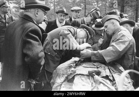 Il dottor Gerhard Buhtz esamina un corpo mentre il dottor Helge Tramsen e altri membri della Commissione medica Internazionale osservano durante l'indagine sul massacro di Katyn. Foto Stock