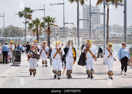 Un gruppo di uomini britannici che visitano morris che camminano nella zona del Porto Vecchio di Paphos, Cipro. I ballerini avevano appena eseguito un ballo per il pubblico Foto Stock