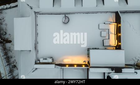 Fotografia in droni della terrazza sul tetto coperta dalla neve durante la sera nevosa d'inverno Foto Stock