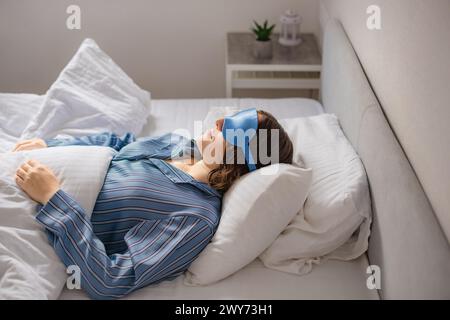 la donna dorme velocemente a letto. maschera di sonno contro l'insonnia Foto Stock