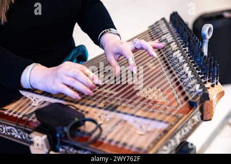 Le mani delle donne suonano lo strumento musicale Qanoon arabo durante una Sinfonia Foto Stock