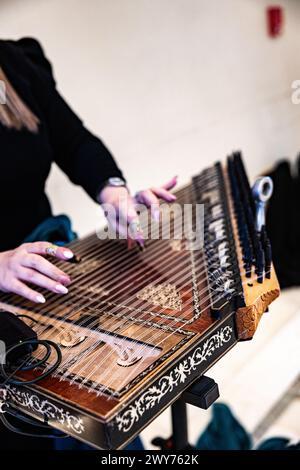 Le mani delle donne suonano lo strumento musicale Qanoon arabo durante una Sinfonia Foto Stock