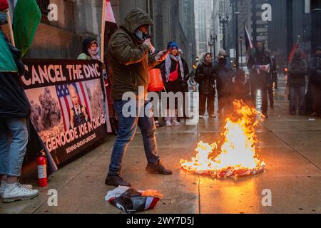 Il veterano del corpo dei Marine Zachary Kam brucia una bandiera americana al municipio di Chicago durante una manifestazione per "annullare il DNC". Foto Stock