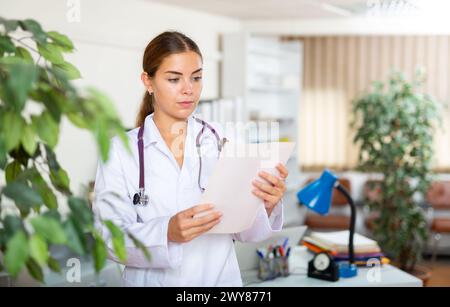 Medico femminile in piedi nella sala della clinica Foto Stock