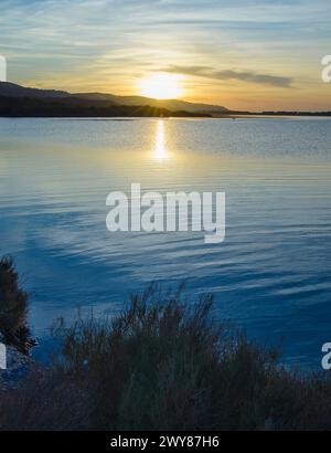 Cielo, terra e mare. Tramonto panoramico nella laguna di Orbetello in Maremma Toscana, Italia Foto Stock