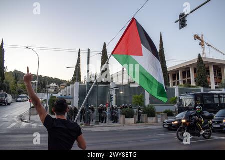 Atene, Grecia. 4 aprile 2024. Un manifestante lancia una bandiera palestinese e grida slogan davanti all'ambasciata degli Stati Uniti durante una marcia di protesta contro la NATO. I ministri degli Esteri si sono riuniti oggi presso la sede della NATO a Bruxelles per celebrare il 75° anniversario dalla firma del documento di fondazione dell'Alleanza, il Trattato del Nord Atlantico. Crediti: Dimitris Aspiotis/Alamy Live News Foto Stock