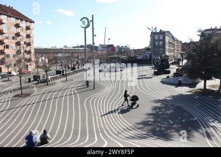 Due persone sono sedute e una donna cammina con un carrozzino a Superkilen. Superkilen è un parco pubblico nel distretto di Norrebro a Copenaghen, Danimarca. Il parco è progettato per riunire immigrati e locali, promuovendo tolleranza e unità in una delle comunità più etnie e socialmente sfidate della Danimarca. Copenhagen Superkilen Danimarca Copyright: XKristianxTuxenxLadegaardxBergx IMG 0643 Foto Stock