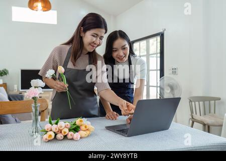 madre e figlia organizzano i fiori insieme come hobby. madre e figlia trascorrono del tempo libero a fare fiori organizzando attività insieme e guardando Foto Stock