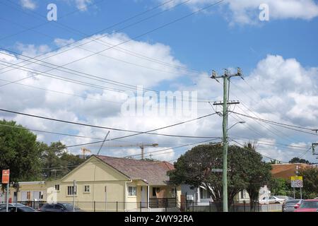 Palo elettrico in legno australiano con fili a bassa e alta tensione su una strada periferica nel sobborgo di Canley vale Western Sydney Foto Stock