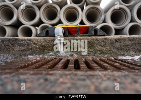 Acqua proveniente da un tubo da una pila di tubi Foto Stock