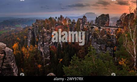 Sassonia, Germania - Vista panoramica del ponte Bastei con un tramonto autunnale soleggiato con fogliame colorato e cielo. Bastei è famosa per la splendida roccia Foto Stock