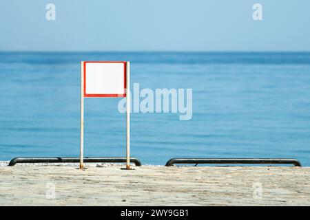 Segnale di avvertimento vuoto sul mare in una giornata d'estate soleggiata e limpida Foto Stock