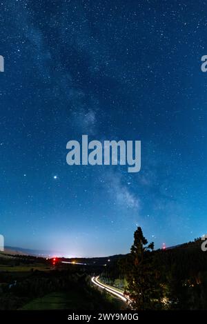Cielo notturno con stelle e galassia dalla via lattea su una strada tortuosa Foto Stock