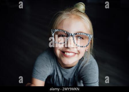 Primo piano ritratto di una ragazza sorridente con gli occhiali che guardano la fotocamera Foto Stock