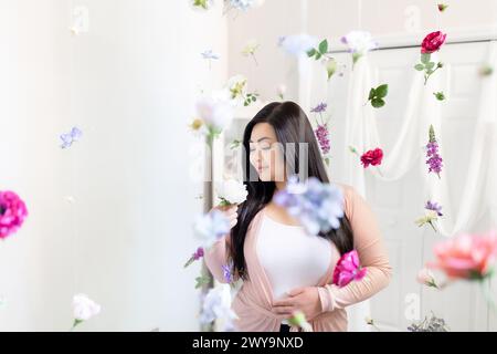 Giovane donna asiatica che medita tra il viola e il rosa pendenti Foto Stock