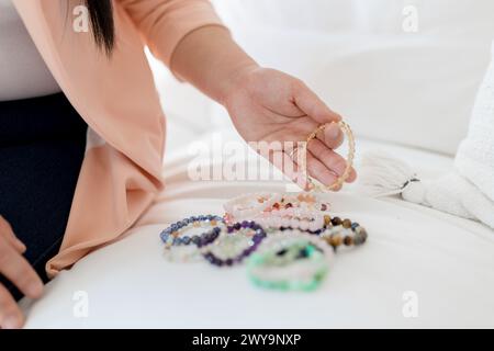 Donna asiatica che seleziona braccialetti con perline per la guarigione spirituale Foto Stock