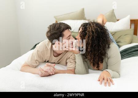 Una coppia condivide un momento di gioia e di chiusura insieme in camera da letto Foto Stock