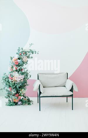 Sedia moderna bianca astratta a parete con fiori primaverili in uno splendido spazio Foto Stock