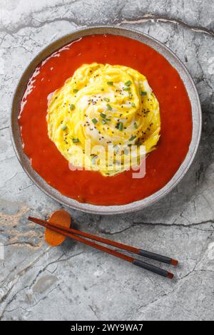 Tornado Omelette Omurice con ketchup Sriracha sul piatto sul tavolo. Vista dall'alto verticale Foto Stock