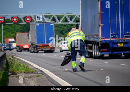 Agente del traffico delle autostrade nazionali che sgombra una corsia dopo un incidente su un'autostrada intelligente in Inghilterra. Foto Stock