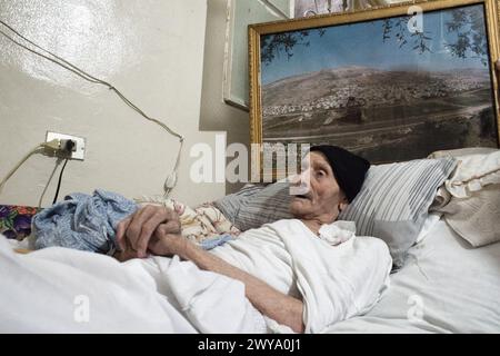 Fotografia di una famiglia palestinese con generazioni diverse che tracciano l'evoluzione del sogno di casa nel campo profughi di Sabra-Shatila Foto Stock