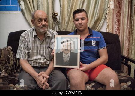 Fotografia di una famiglia palestinese con generazioni diverse che tracciano l'evoluzione del sogno di casa nel campo profughi di Sabra-Shatila Foto Stock