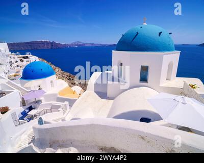 Le iconiche chiese a cupola blu della Resurrezione del Signore e di San Spyridon, il villaggio di Oia, l'isola di Santorini Thira, le Cicladi, le isole greche, Grecia, Europ Foto Stock