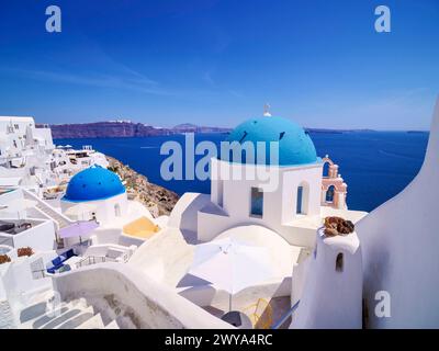 Le iconiche chiese a cupola blu della Resurrezione del Signore e di San Spyridon, il villaggio di Oia, l'isola di Santorini Thira, le Cicladi, le isole greche, Grecia, Europ Foto Stock