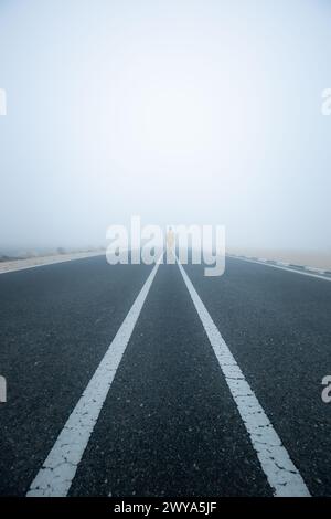 Una persona che cammina su una strada nebulosa, Doha Qatar Foto Stock