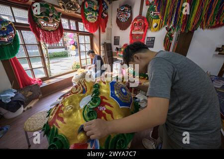 Primo piano di un dipinto artigianale disegni elaborati su una brillante scultura di drago dorato Foto Stock