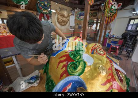 Primo piano di un dipinto artigianale disegni elaborati su una brillante scultura di drago dorato Foto Stock