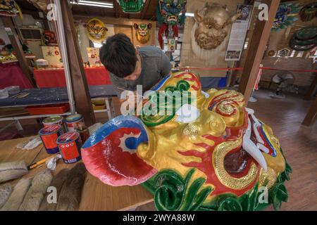 Primo piano di un dipinto artigianale disegni elaborati su una brillante scultura di drago dorato Foto Stock