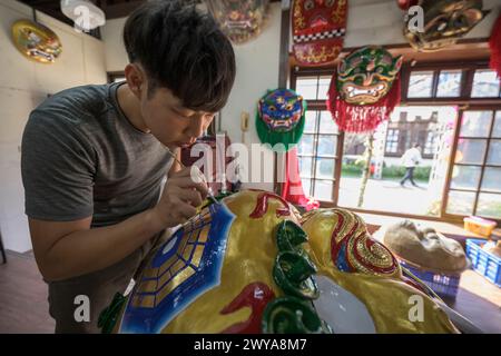 Primo piano di un dipinto artigianale disegni elaborati su una brillante scultura di drago dorato Foto Stock