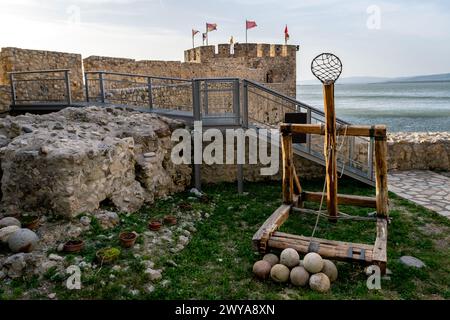 Antica replica medievale di catapulta e palle di cannone presso la fortezza Golubac in Serbia. Europa. Foto Stock