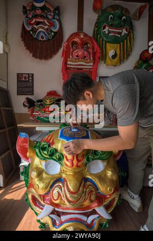 Primo piano di un dipinto artigianale disegni elaborati su una brillante scultura di drago dorato Foto Stock