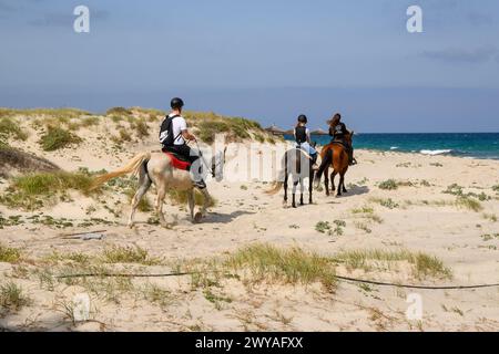 Kos, Grecia - 12 maggio 2023: Persone a cavallo sulla spiaggia di Marmari. Isola di Kos, Grecia Foto Stock