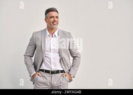 Un imprenditore felice di mezza età che guarda lontano isolato sul muro bianco. Foto Stock