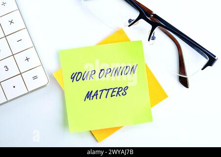 LA TUA OPINIONE CONTA una frase scritta su un adesivo giallo su sfondo bianco Foto Stock
